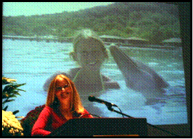 Lady standing at podium with Projected rear screen image behind her